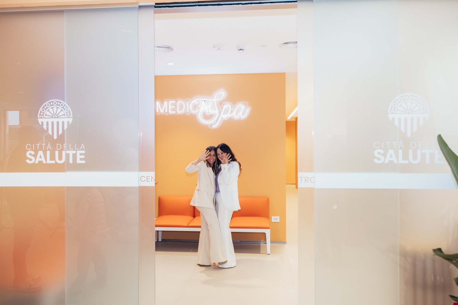 Le estetiste della Medical Spa all'ingresso, sotto l'insegna al neon
